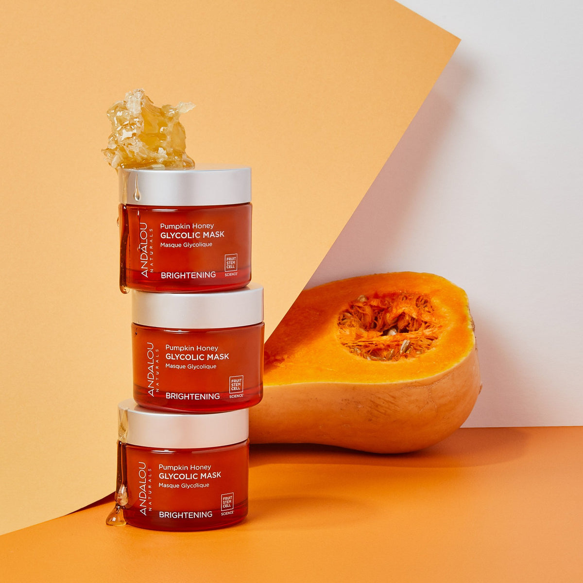 tow of Brightening Pumpkin Honey Glycolic Mask jars with honeycomb and half of a butternut squash